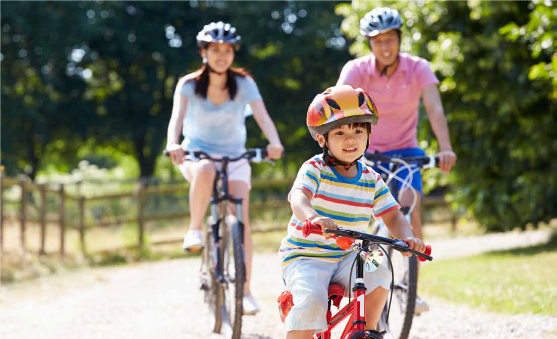 Family riding bikes in a park