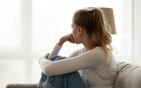 An image showing a young person looking out a window 