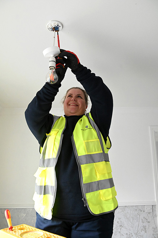 A person fitting a ceiling light.