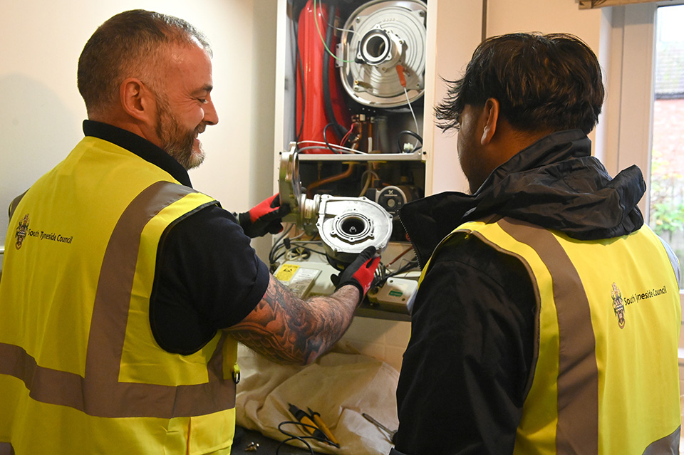 Two people working on a boiler