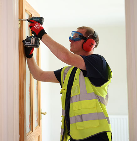 A worker repairing a door