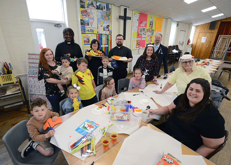 People around a table with craft activities.