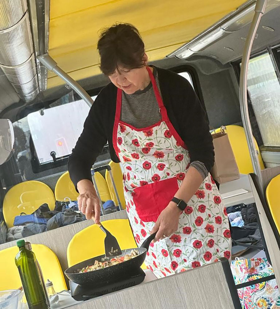 A woman giving a cookery demonstration in a bus.