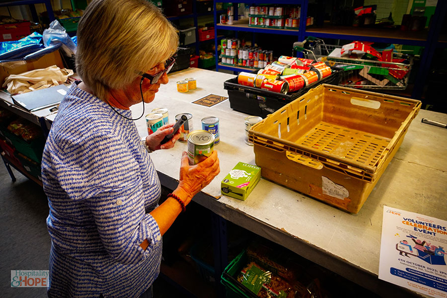 A woman filling a box with food at a food bank.