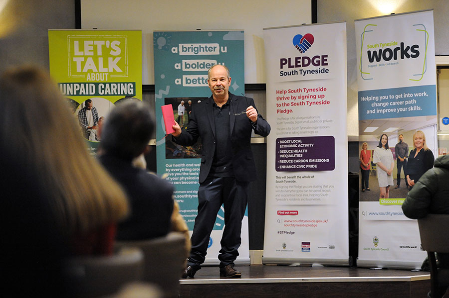 A man giving a presentation a stage.