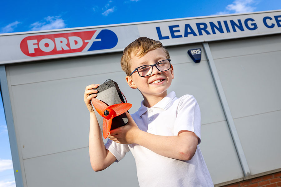 A young boy, holding a small turbine.